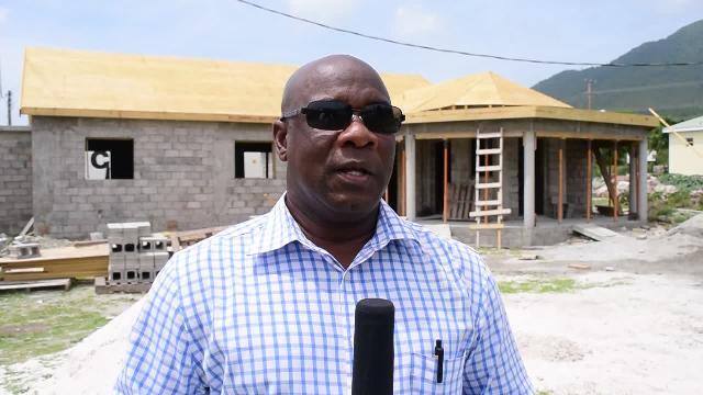 Minister of Agriculture on Nevis Hon. Alexis Jeffers at Prospect on April 27, 2016 with the new wing of the government-owned Abattoir under construction in the background