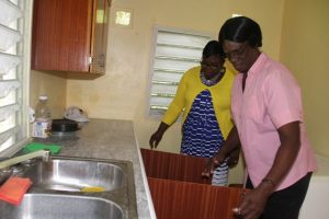 Homeowner Mrs. Yvonne Stanley (right) and Hon. Hazel Brandy-Williams, Junior Minister in the Ministry of Social Development take a look at refurbishment work done under the Ministry’s Community Housing Assistance Programme, moments after Mrs. Brandy-Williams handed over the keys on October 19, 2017