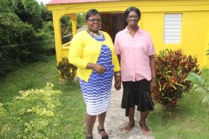 Hon. Hazel Brandy-Williams, Junior Minister in the Ministry of Social Development with homeowner Mrs. Yvonne Stanley in front her newly renovated Fig Tree home on October 19, 2017.