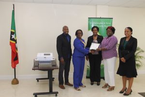 (l-r) Mr. Timothy Caines and Mrs. Jacqueline Brooks-Jeffers, Members of the St. Christopher and Nevis Social Security Board hand over an EKG machine, a gift from the Board, to Hon. Hazel Brandy Williams, Minister of Health; Dr. Judy Nisbett, (centre); and Mrs. Nicole Slack-Liburd, Permanent Secretary in the Ministry of Health on May 18, 2018 at the Social Security Building in Nevis