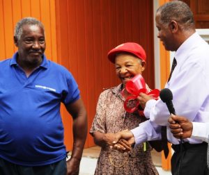 Hon. Eric Evelyn, Minister responsible for Social Development on Nevis handing over the keys to a new home to Ms. Lorraine Cassandra Phillip. Her partner Hillary Shield looks on