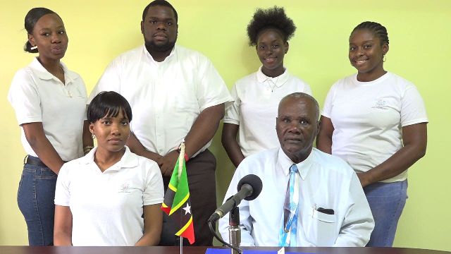 Hon. Farrel Smithen, President of the Nevis Island Assembly, introducing Youth Parliamentarians taking part in the 14th Regional Youth Parliament Debate in the Cayman Islands on Friday June 22, 2018; (sitting left) Ms. Uta Taylor, chaperon; (standing l-r) Ms. Celestial Hanley, Mr. Rol-J Williams, Ms. Charlyn Myers and Ms. Lauren Lawrence