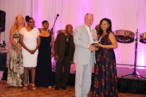 Mr. Tim Thuell, General Manager of the Nisbet Plantation Beach Club at Newcastle in Nevis, with some members of his staff accepting the Ministry of Tourism’s Hotel of the Year Award from Mrs. Sharon Brantley, wife of Minister of Tourism Hon. Mark Brantley at the ministry’s annual Tourism Awards Gala and Dance at the Four Seasons Resort on May 27, 2017