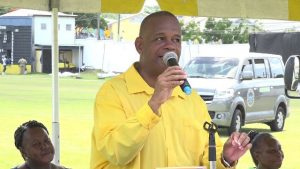 Hon. Eric Evelyn, Minister responsible for seniors on Nevis, delivering remarks at a ceremony at the Elquemedo T. Willett Park, following a march for seniors through Charlestown on October 05, 2018. Sitting on his left is Ms. Sandra Maynard, Director of the Department of Social Services and on his right, Mrs. Ann Wigley, Director of the Social Services Department in St. Kitts