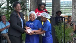 Dr. Judy Nisbett, Medical Officer of Health, presents a trophy to 2nd place winners in the MyHealthyPlate Junior Chef Competition, to Ms. Kianna Phillip and Mr. T'zharee Stephenson of the Violet O. Jeffers Nicholls Primary School, at the Nevis Performing Arts Centre courtyard on April 15, 2019