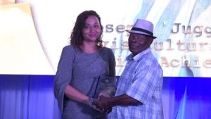 Mr. Joseph "Juggo" Brandy receives the award for Nevis Cultural Tourism Lifetime Achievement Award from First Lady Mrs. Sharon Brantley at the Ministry of Tourism’ s Nevis Tourism Industry Awards ceremony on May 25, 2019, on the grounds of Government House at Bath Plain