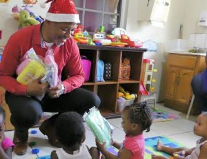 Hon. Spencer Brand, Area Representative for the St. Paul’s Parish distributing Christmas gifts to students at the Steppin’ Stone Nursery at Stoney Grove in Charlestown recently