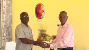 (L-r) Mr. Alsted Pemberton, outgoing Director of the Social Policy and Sustainable Human Development Unit, receives a fruit basket as a token of appreciation from Hon. Eric Evelyn, Minister of Social Development for his sterling contribution to the ministry and the people of Nevis at a retirement ceremony at the Nevis Performing Arts Centre courtyard on May 8, 2020