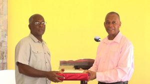 (L-r) Mr. Alsted Pemberton, outgoing Director of the Social Policy and Sustainable Human Development Unit, receives a gift as a token of appreciation from Hon. Eric Evelyn, Minister of Social Development for his sterling contribution to the ministry and the people of Nevis at a retirement ceremony at the Nevis Performing Arts Centre courtyard on May 8, 2020