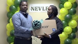 Mr. Kayno David, Deputy Principal at the Gingerland Secondary School, receiving a laptop from Ms. Antoinette Daniel, a member of the Nevis Electricity Company Limited’s 20th Anniversary Organising Committee, at a handing over ceremony at the company’s board room on August 26, 2020