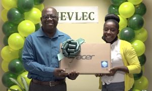 Mr. Juan Williams, Principal of the Charlestown Secondary School, receiving a laptop from Ms. Curleane Liburd, a member of the Nevis Electricity Company Limited’s 20th Anniversary Organising Committee, at a handing over ceremony at the company’s board room on August 26, 2020