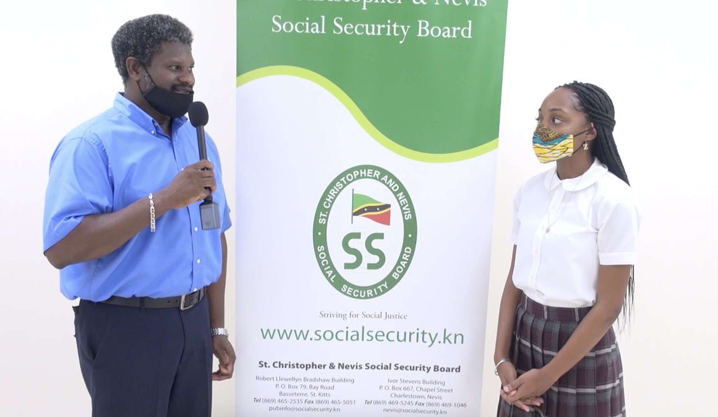 l-r) Mr. Donovan Herbert, Senior Branch Manager of the St. Christopher and Nevis Social Security Board, Nevis Branch thanking Ms. Zwena Jones of Zee’s Exquisite Apparel Line (ZEAL), a budding entrepreneur, recipient of a St. Christopher and Nevis Social Security Board Scholarship and a student of the Nevis Sixth Form College at the Social Security’s Board Room at Pinney’s Estate on September 25, 2020, for her donation of 25 fabric masks to the Branch members to assist in their fight against COVID-19