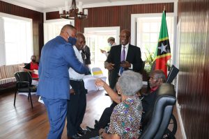 Hon. Mark Brantley, Premier of Nevis sharing a light moment with family members of Dr. Albert Linton Liburd Sr.’ moments after receiving the 2020 Medal of Honour from Her Honour Mrs. Hyleeta Liburd, Deputy Governor General on Nevis at an Investiture Ceremony at Government House at Bath Plain on September 09, 2021