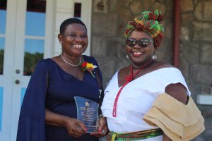 (L-r) Independence Day Awardee Mrs. Palsy Wilkin sharing a light moment with her sister Hon. Hazel Brandy-Williams after receiving a plaque from Her Honour Mrs. Hyleeta Liburd, Deputy Governor General on Nevis at an Awards Ceremony at Government House on September 20, 2021, in honour of her sterling contribution to Education in St. Kitts and Nevis on the occasion of the Federation's 38th Anniversary of Independence