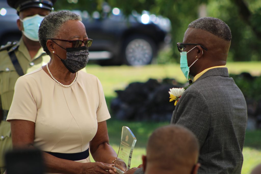 Mr. Carlisle “King Binghi” Pemberton of Brown Hill is presented with a plaque in honour of his contribution to Music by Her Honour Mrs. Hyleeta Liburd, Deputy Governor General in Nevis at an Awards Ceremony at Government House on September 20, 2021 on the occasion of the 38th Anniversary of Independence of St. Christopher and Nevis