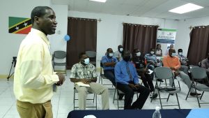 Mr. Dion Browne, Gender Field Officer in the Ministry of Social Development and Gender Affairs on St. Kitts, at the Department of Gender Affairs conference room on November 16, 2021, with would-be mentors at the first training session for the Boys' Mentorship Programme in Nevis   