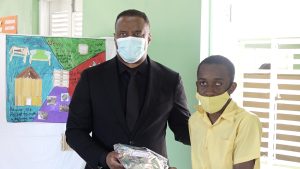 Hon. Mark Brantley, Premier of Nevis and Minister of Tourism, presents Kijaunte Hobson of the Cecele Browne Integrated School with gifts for placing third in the Ministry of Tourism’s 2022 Environmental Poster Contest